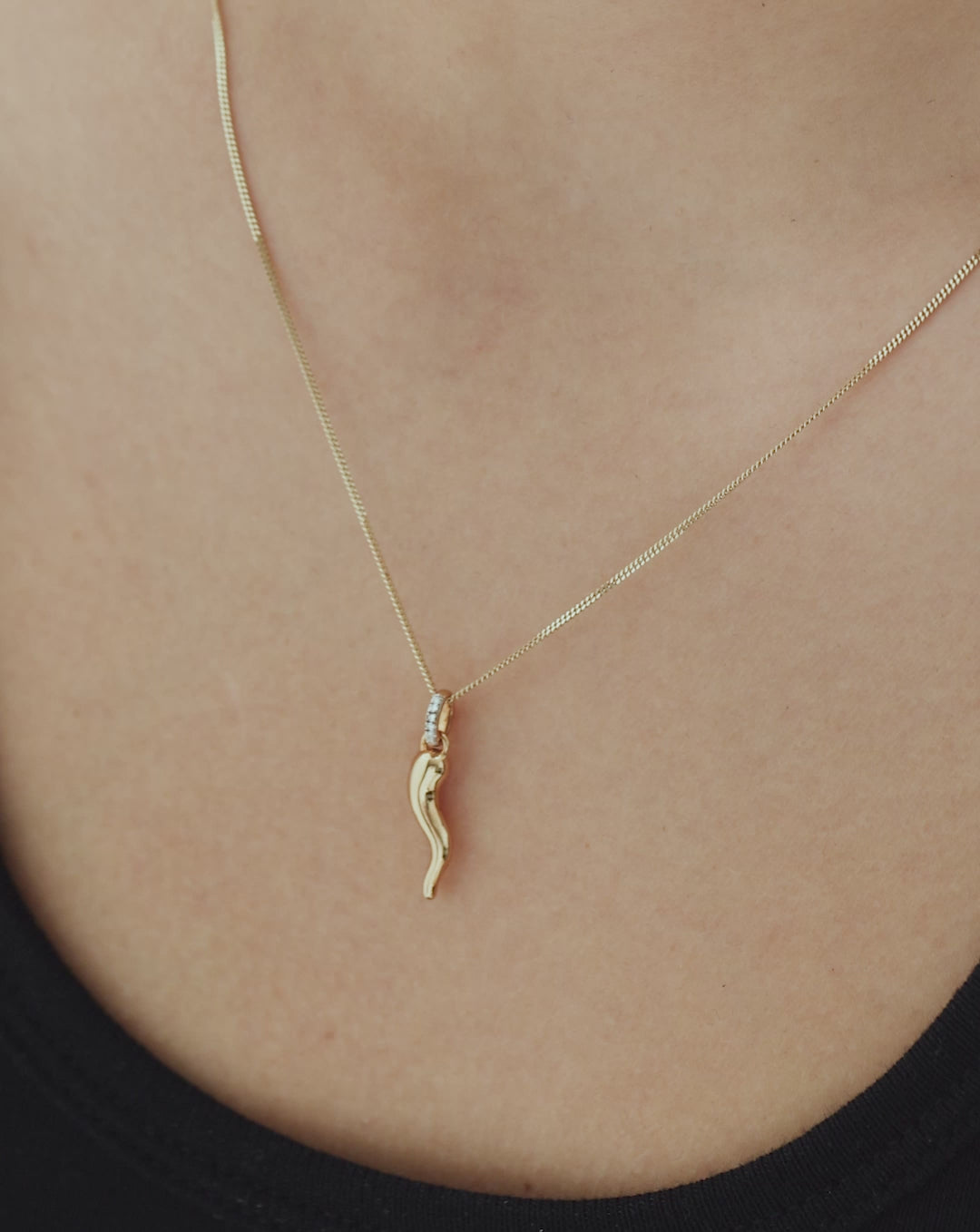 video showing the Cornicello Charm on yellow gold necklaces styled on different models