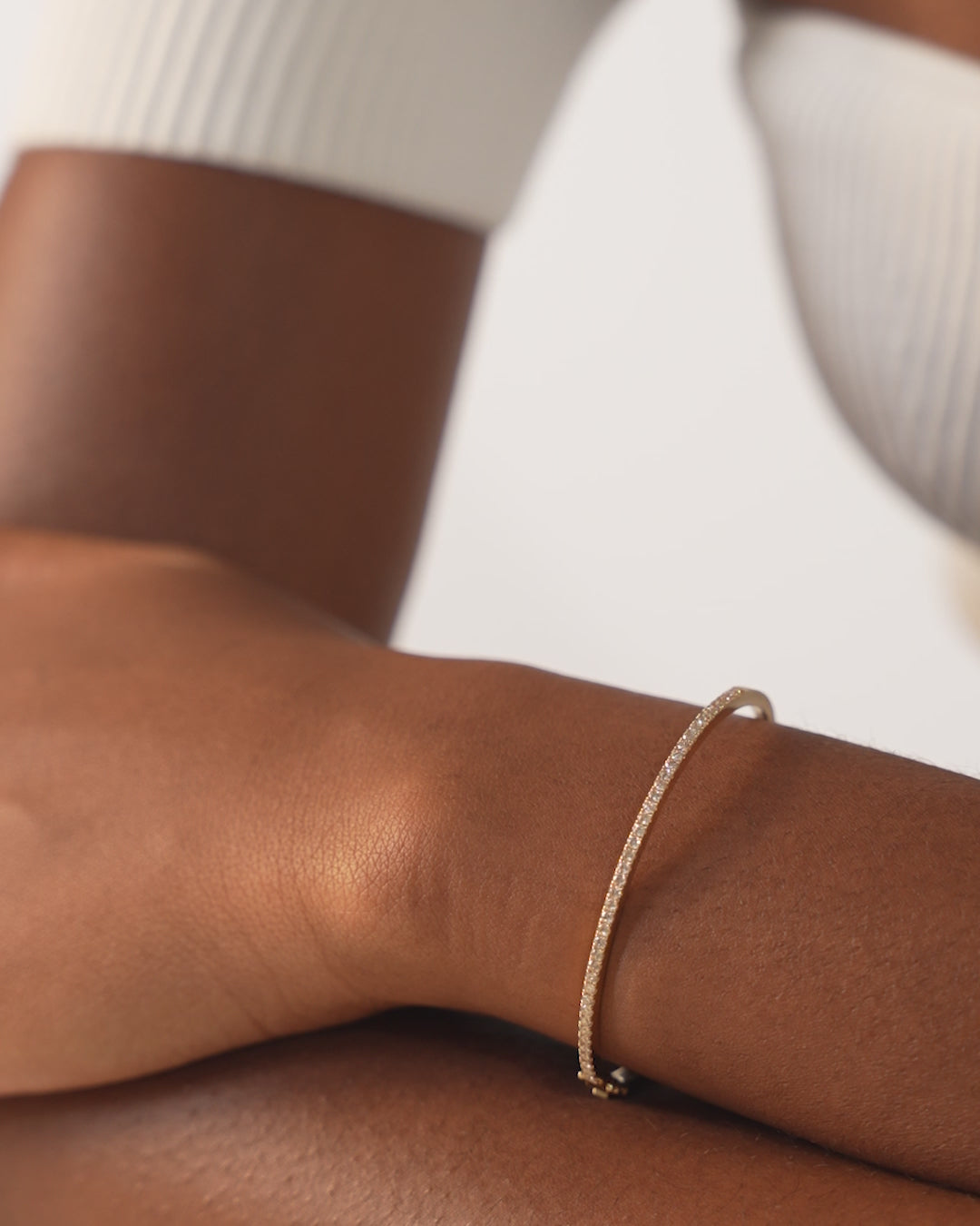 Video of Classic Diamond Bangle in 14k Yellow Gold shown solo on wrist as well as styled on another wrist with other yellow gold tennis bracelets and bangles