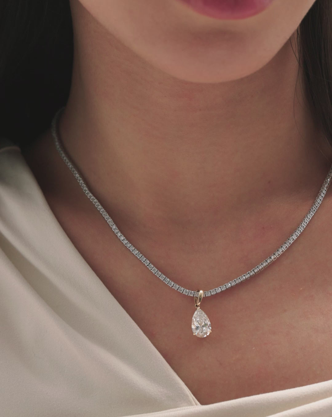 video of model wearing pear diamond charm pendant on necklace