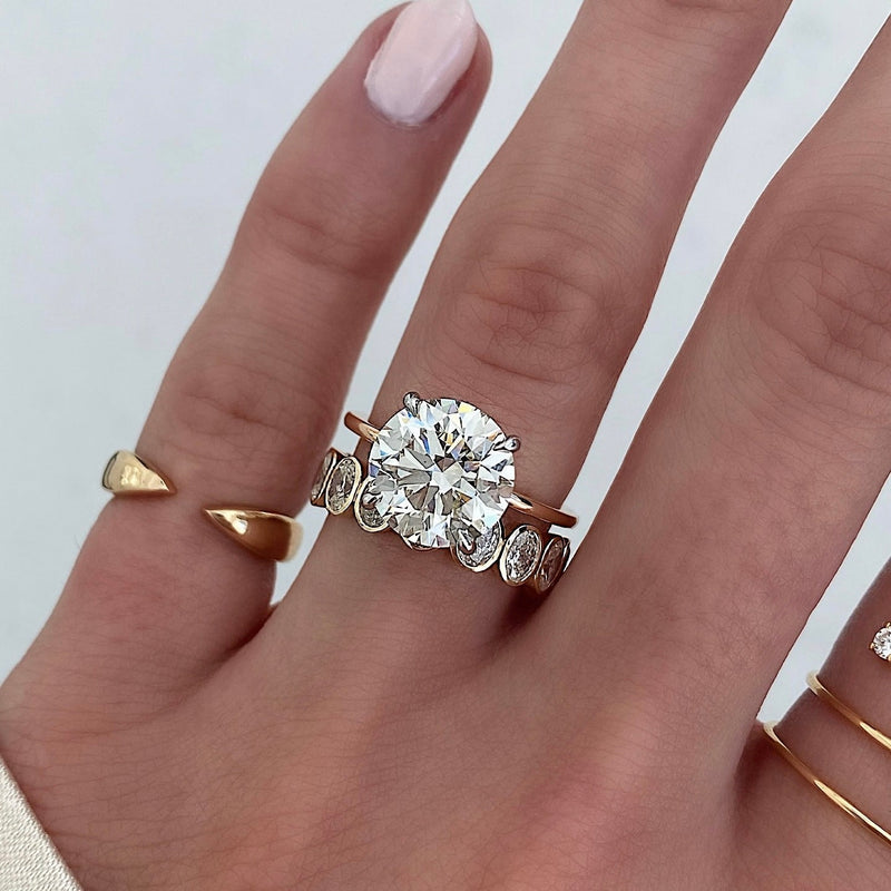 Bridal Wedding Bands Petite Oval Bezel Eternity Band on model stacked with round engagement ring