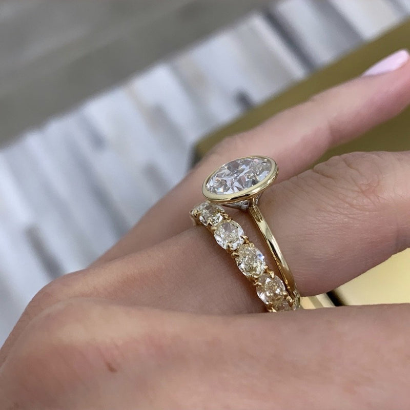 Bridal Wedding Bands Sideways Oval Yellow Band on model paired with bezel set round engagement ring
