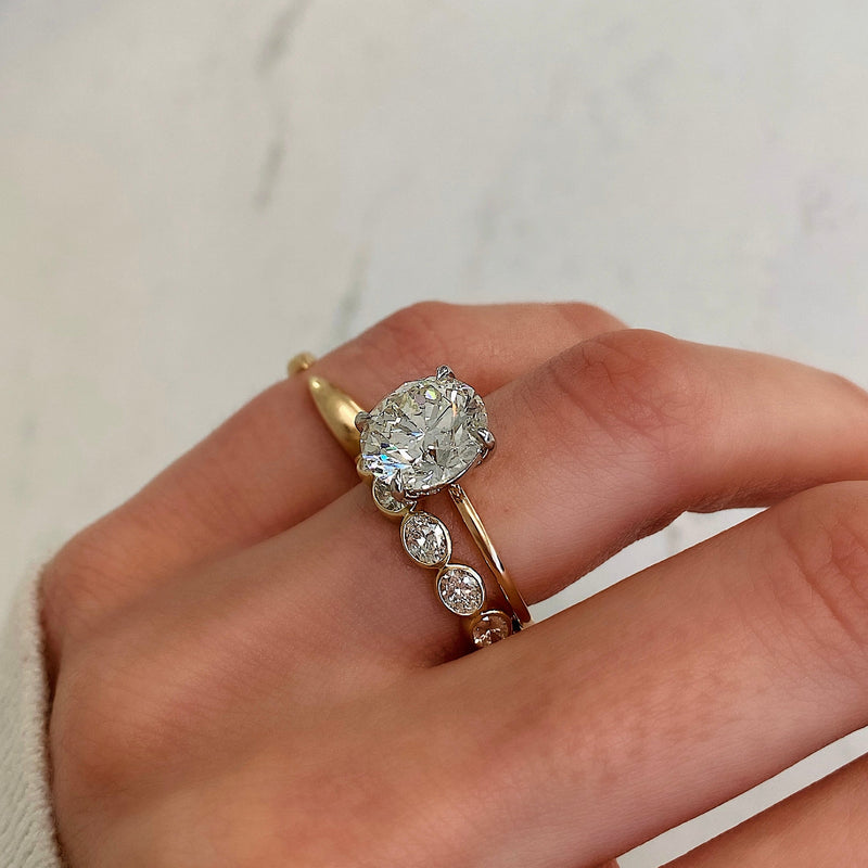 Bridal Wedding Bands Sideways Petite Oval Bezel Eternity Band on model paired with round engagement ring
