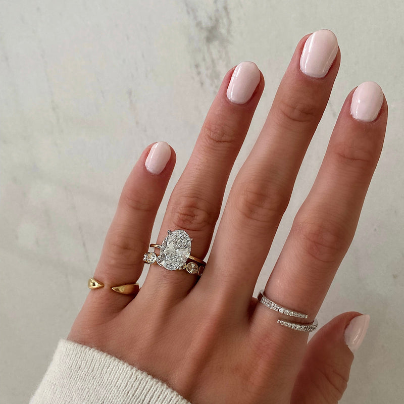 Bridal Wedding Bands Sideways Petite Oval Bezel Eternity Band on model paired with oval engagement ring