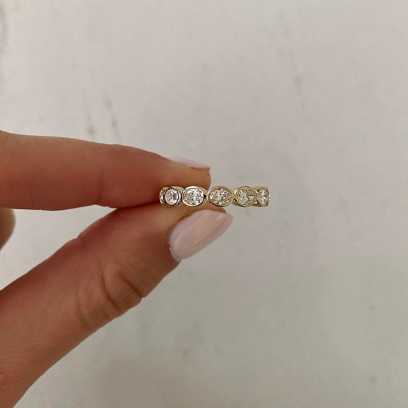 Bridal Wedding Bands Sideways Petite Oval Bezel Eternity Band model holding ring to show detail