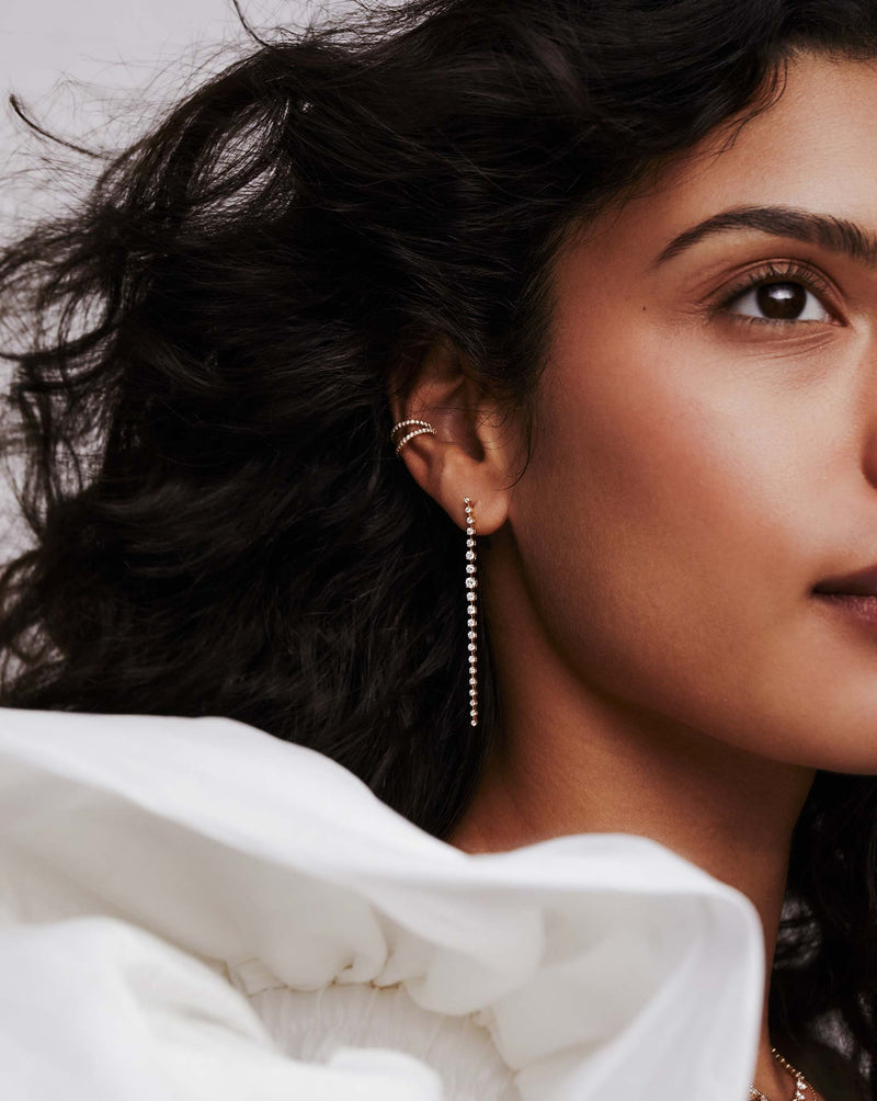 open double row diamond ear cuff and graduate diamond long drop earrings on model wearing white ruffle top