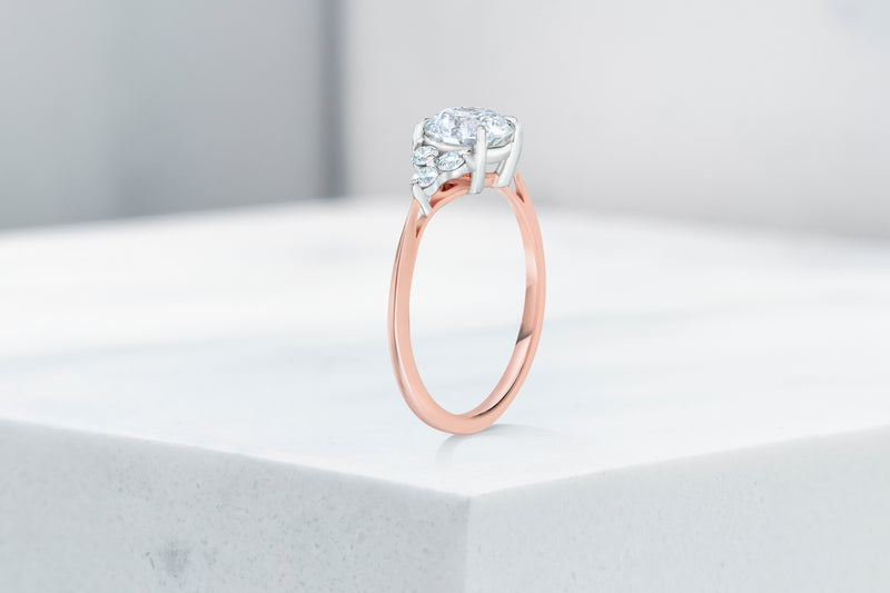 Tribeca VOW by Ring Concierge round with trio side stones engagement ring in rose gold. 33281407647832