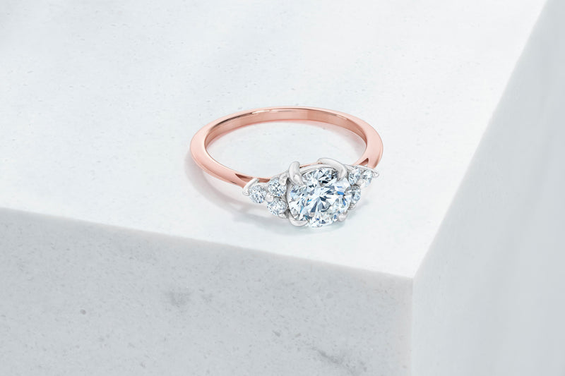 Tribeca VOW by Ring Concierge round with trio side stones engagement ring in rose gold. 33281407647832